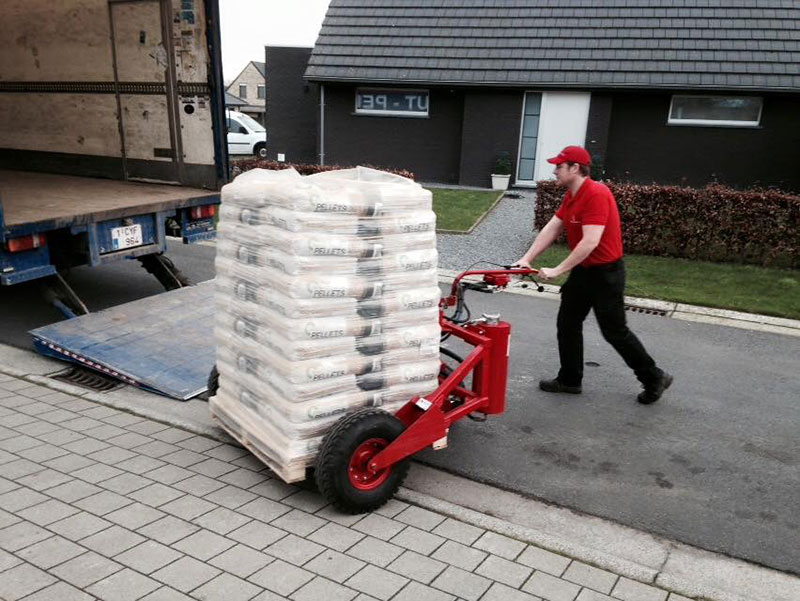 Zustellung einer Palette mit Hubwagen vor einem Haus